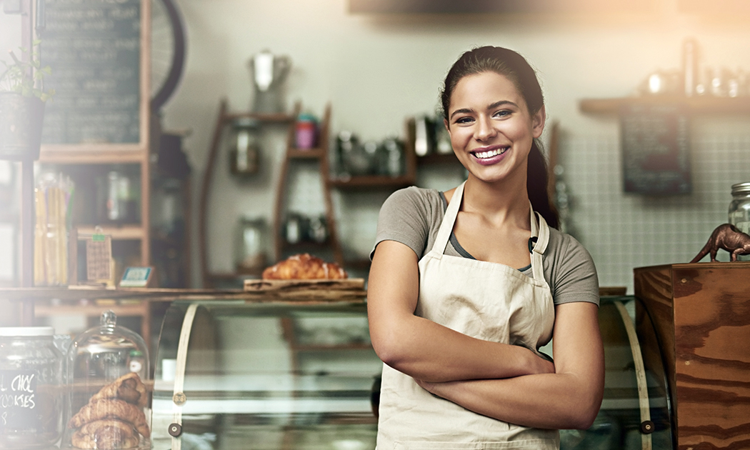 Employee standing in front of food display at coffee shop