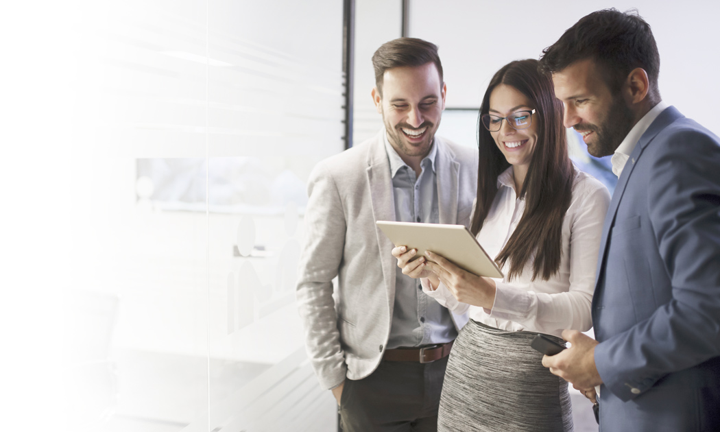 Three professionals looking at a tablet